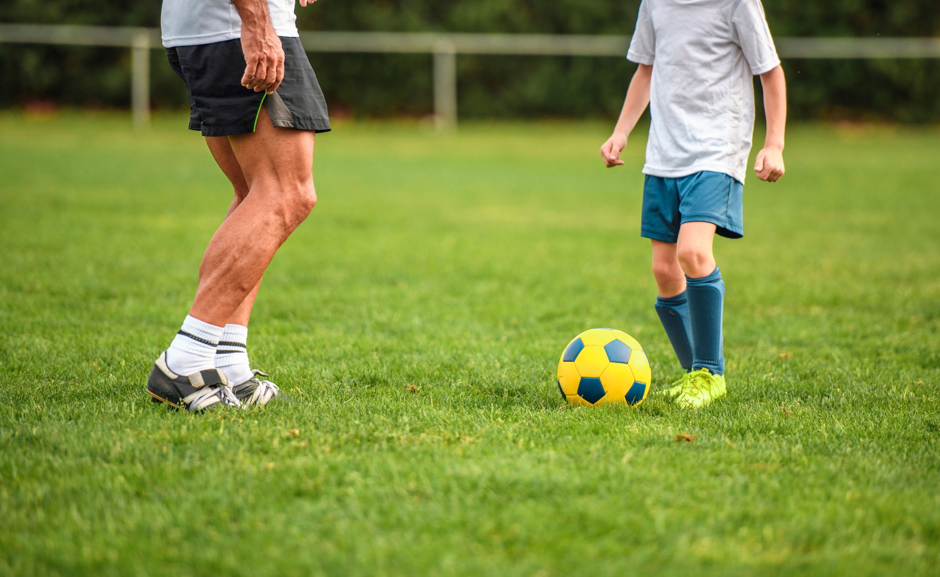 Coach and Young Boy Footballer Practicing Ball Control